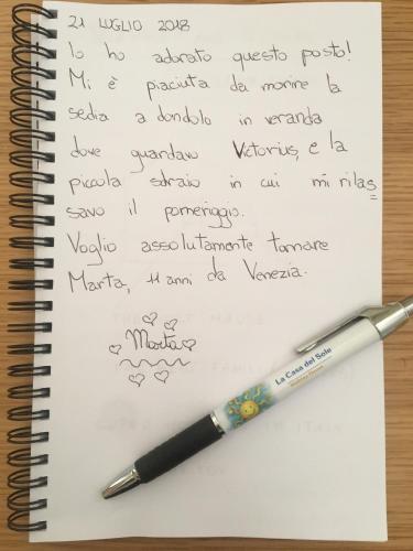a handwritten letter with a pen on a notebook at La Casa del Sole in Marina di Pisticci