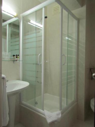 a bathroom with a glass shower and a sink at Vera Cruz Porto Downtown Hotel in Porto