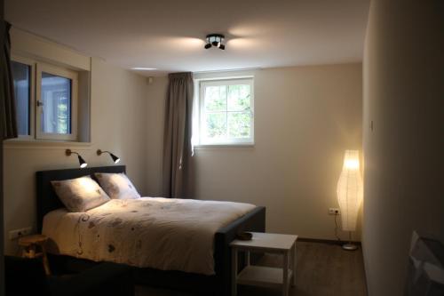 1 dormitorio con cama y ventana en Bed & Breakfast Op 't Leven, en Ermelo