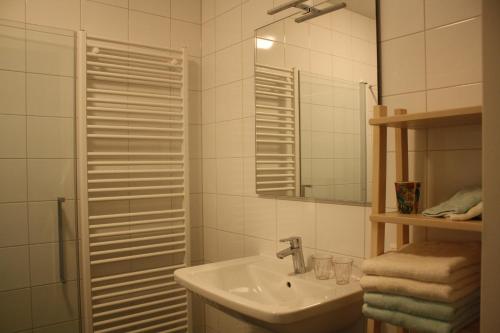 Baño blanco con lavabo y espejo en Bed & Breakfast Op 't Leven, en Ermelo