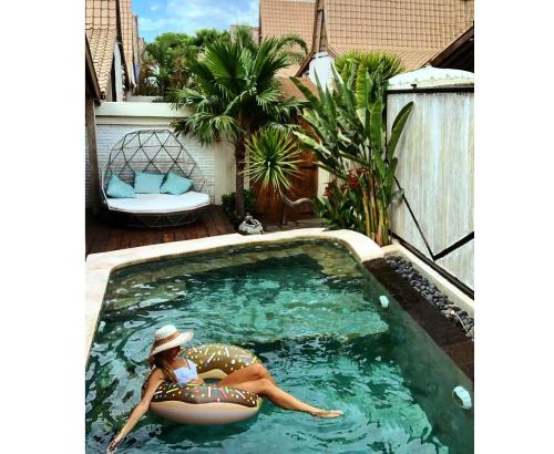 a woman laying on an inflatable ball in a swimming pool at Kaleydo Villas in Gili Trawangan
