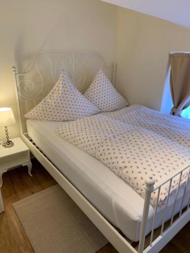a white bed with polka dot pillows on it at Ferienwohnung Giacomelli 3 in Rottach-Egern