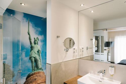La salle de bains est pourvue d'une statue de liberté sur le mur. dans l'établissement Germanenhof, à Sandebeck