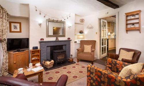 a living room with a fireplace and a tv at Treacle Cottage in Ambleside