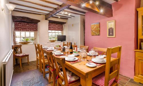 a dining room with a wooden table and chairs at Treacle Cottage in Ambleside
