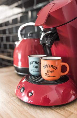 two coffee cups on top of a red blender at Studio Le Perreux proche Paris et Disneyland in Le Perreux-Sur-Marne