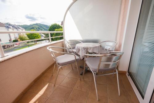 a table and chairs on a balcony with a view at Apartmani Strsoglavec in Krapinske Toplice