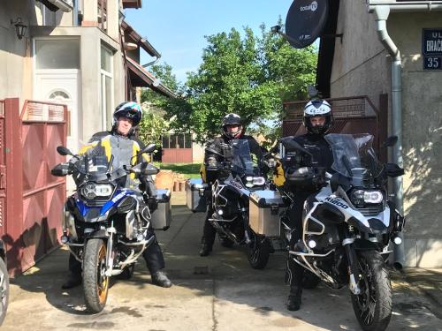 three people on motorcycles parked outside a building at Santa Maria Apartment in Donji Kovilj