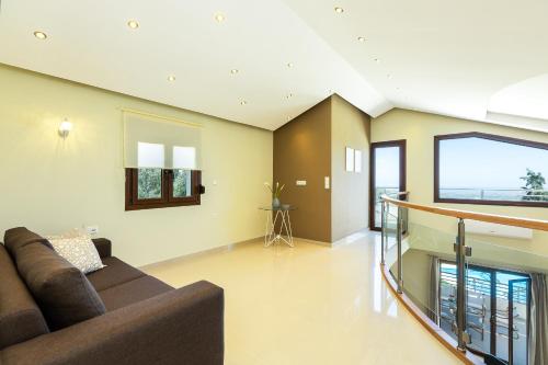 a living room with a couch and a large window at Anatoli Villa, Tranquil Retreat, By ThinkVilla in Orthés