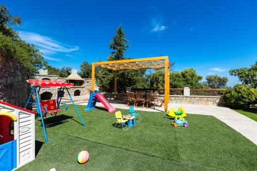 a playground with play equipment on the grass at Anatoli Villa, Tranquil Retreat, By ThinkVilla in Orthés