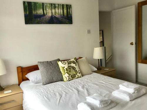 a bedroom with a white bed with two pillows at The Woodfarm Lodge - 3 Bedroom House with free Parking in Oxford