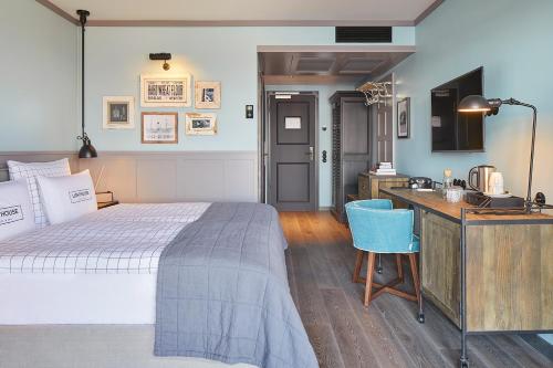 a bedroom with a bed and a desk with a computer at Lighthouse Hotel & Spa in Büsum