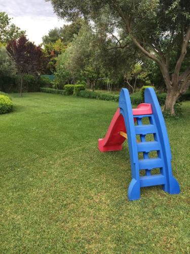 a playground with a plastic slide in the grass at CASA DI MADI in Chalkida