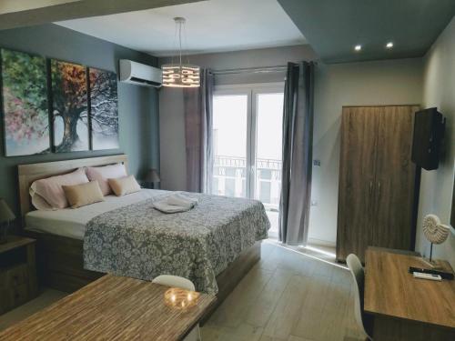 a bedroom with a bed and a table and a window at Haus Viktoria 1 in Limenas
