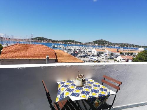 a table on a balcony with a view of a marina at Apartman Dino in Murter