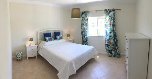- une chambre avec un lit blanc et une fenêtre dans l'établissement Villa Vale Carro, à Albufeira