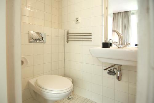 Wooden Mill B&B في أمستردام: حمام ابيض مع مرحاض ومغسلة
