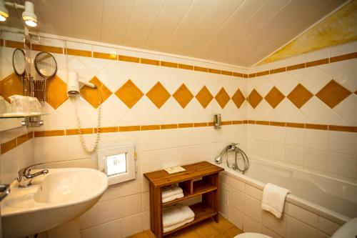uma casa de banho com um lavatório, um WC e uma banheira em LOGIS HOTEL RESTAURANT L' Auberge d'Uzes em Uzès