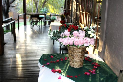 a vase of flowers on a table on a table at Tuskers Bush Lodge B&B in Hartbeespoort