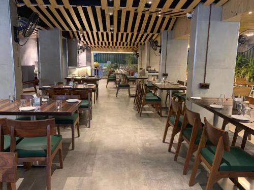 a dining room with wooden tables and chairs at Centro in Pune