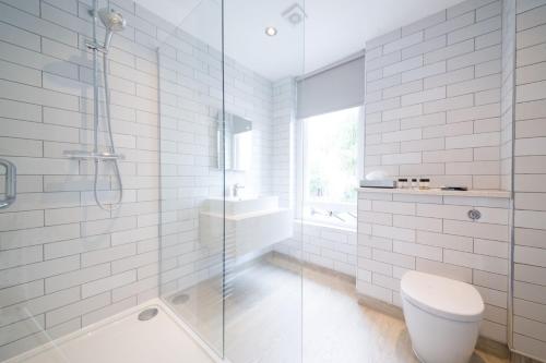 a bathroom with a shower and a toilet and a sink at The Beverley by Innkeeper's Collection in Cardiff