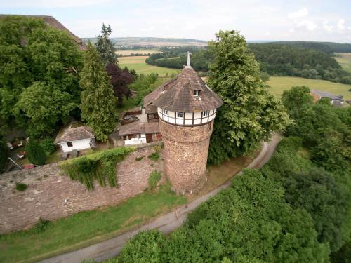 an aerial view of a stone tower with a house at Hotel Burg Trendelburg in Trendelburg