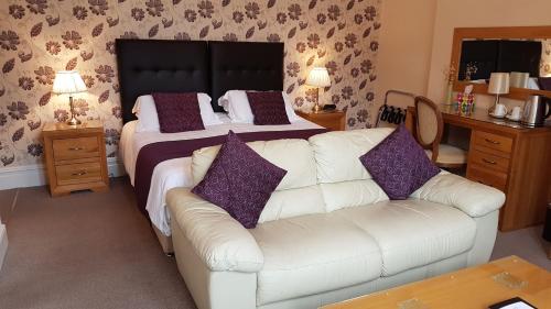 a living room with a white couch and a bed at Paignton Court in Paignton