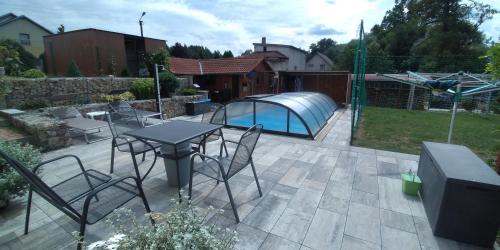 a patio with a table and chairs and a pool at Apartmán u potoka in Sadov