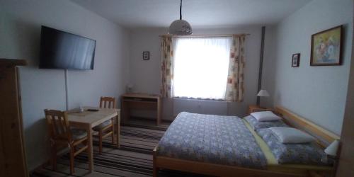 - une chambre avec un lit, une table et une fenêtre dans l'établissement Apartmán u potoka, à Sadov