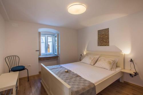 a bedroom with a bed and a desk and a window at Apartmani Kraj mora in Cres
