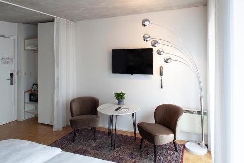 a bedroom with a table and two chairs and a tv at BANKS Antwerp in Antwerp