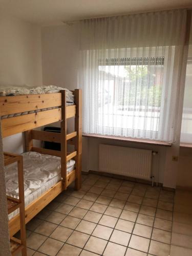 Cette chambre comprend 2 lits superposés et une fenêtre. dans l'établissement Haus Horst, à Schillig