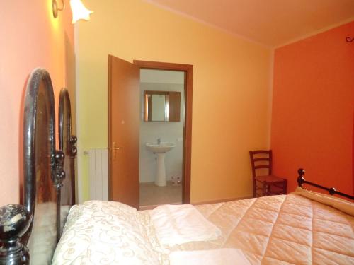 1 dormitorio con 1 cama y baño con lavamanos en Agriturismo Lerno, en Pattada