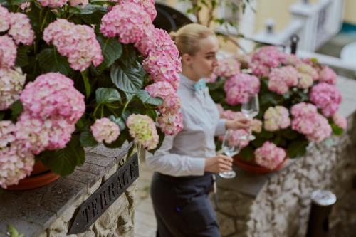 a woman holding wine glasses in front of flowers at Vozdvyzhensky Boutique Hotel in Kyiv