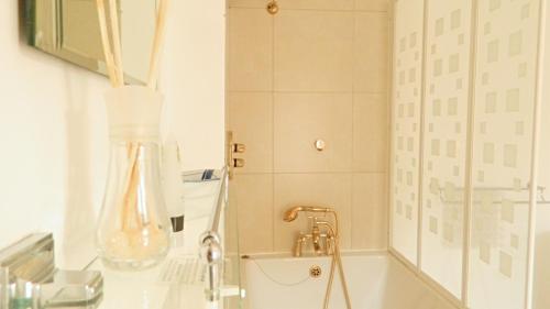 沃里克的住宿－沃里克金斯赫德酒店，浴室配有盥洗盆和带镜子的淋浴