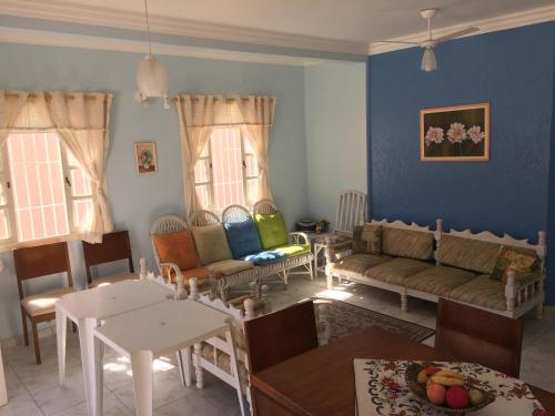 ein Wohnzimmer mit einem Sofa und Stühlen in der Unterkunft CASA NO CENTRO DE BERTIOGA in Bertioga