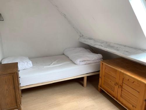 uma pequena cama com duas almofadas num quarto em Beuger 15 em Nieuwpoort
