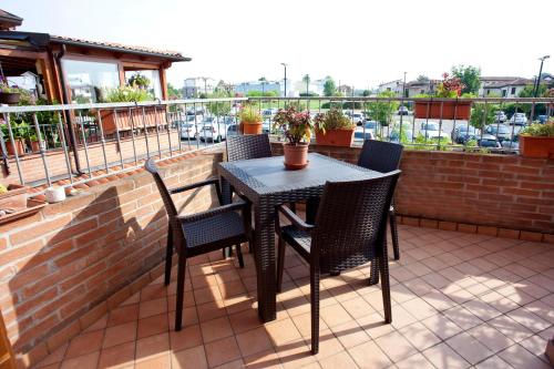 a table and chairs on a patio with a balcony at Locazioni Turistiche By Max in Montegrotto Terme