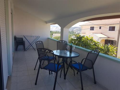 a patio with a table and chairs on a balcony at APARTMANI VIBOVEC Lana 305 in Lopar