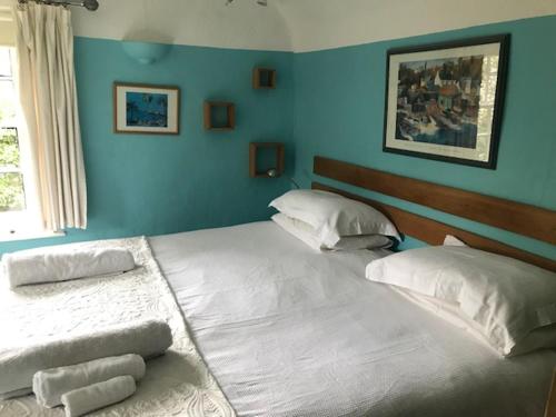 two beds in a bedroom with blue walls at The White House in Takeley