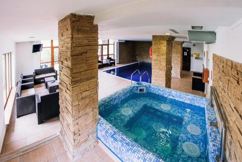 a swimming pool in a house with a tile floor at Pension Casa Humor in Gura Humorului