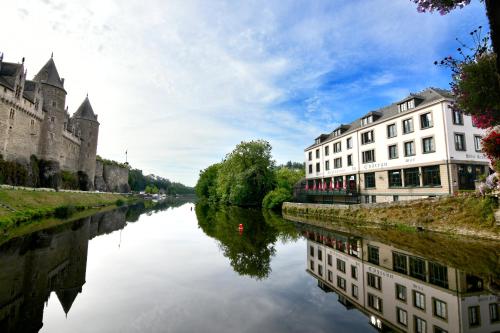 a river in front of a building next to a castle at Hôtel Restaurant Du Château in Josselin