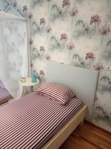 a bedroom with two beds with pink flowers on the wall at Karditsa Home Sweet Home 80 τ.μ in Kardítsa