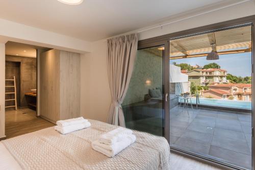a bedroom with a bed and a large window at Ktima Fabiatos in Skala Kefalonias