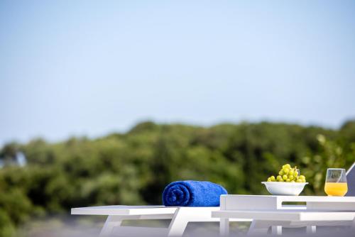 a table with a bowl of fruit and a glass of wine at Ktima Fabiatos in Skala Kefalonias