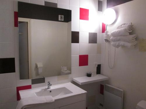 un baño con lavabo y espejo en Logis Hotel Les Gravades Ussel, en Ussel