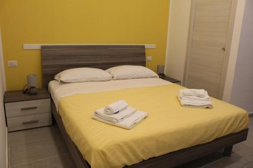 a bedroom with a bed with towels on it at Naxos Laguna Beach in Giardini Naxos