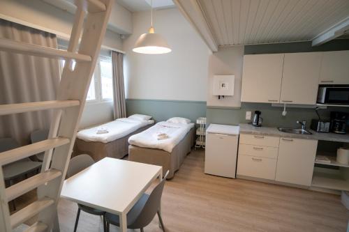 a small room with two beds and a kitchen at Innotelli Apartments in Helsinki