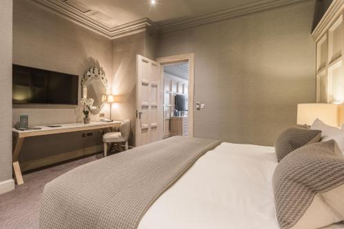 a bedroom with a bed with a desk and a computer at The Scotsman Hotel in Edinburgh