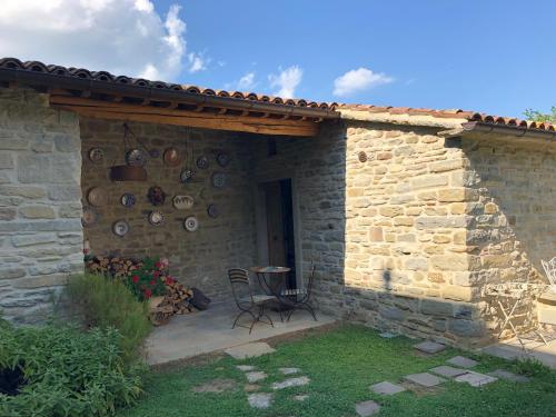 a stone house with a table and a patio at La Locanda Della Campanara in Santa Sofia